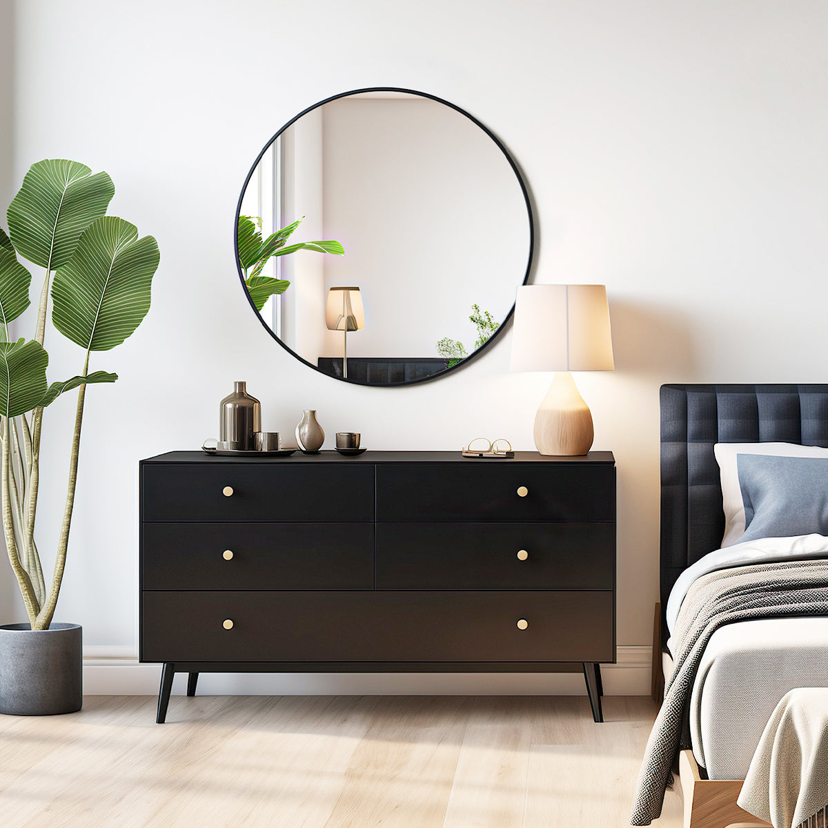 round black frame mirror for bedroom mounted on white wall above black dresser